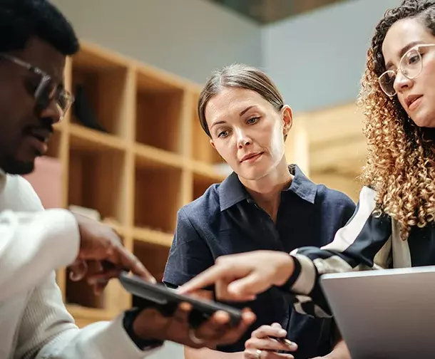 Three people discussing something over technology
